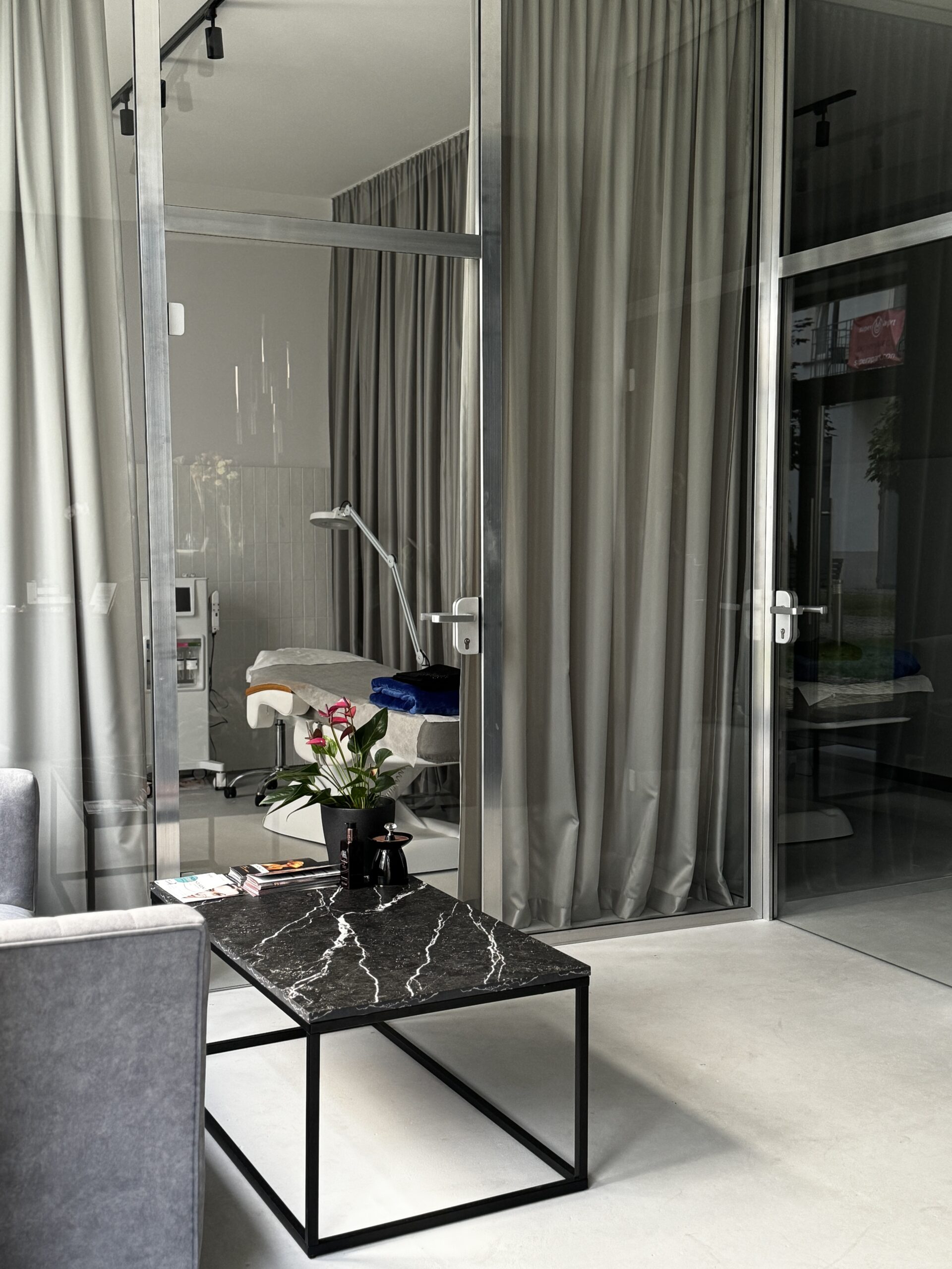 Gabinet zabiegowy kliniki KAMSKIN ze stolikiem i zasłonami